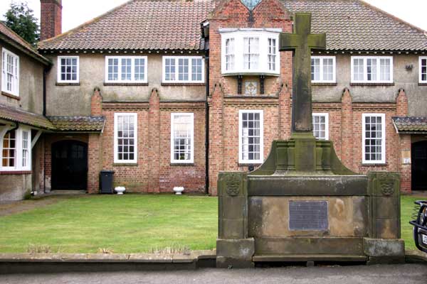 The Village Hall, East Rounton, with the War Memorial in front.