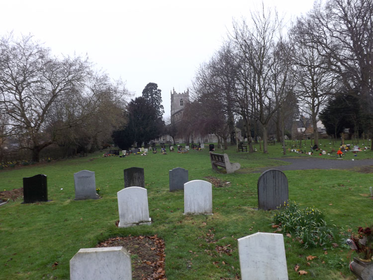 Brampton Cemetery (Huntingdonshire), with the Church of St. Mary Magdalene in the background.