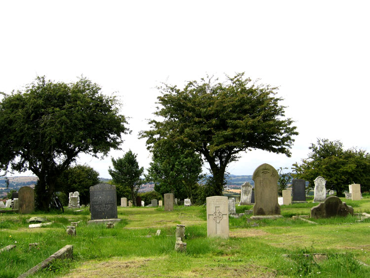 A view of Brotton Church Cemetery with the headstone for Private Thomas in the foreground. 
