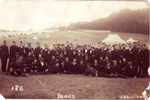 10th Battalion the Yorkshire Regiment in various dress October 1914. Some in civilian clothes, some in Kitchener Blue and the NCO’s wearing the prewar Scarlet Tunic. Note the use of wooden rifles for drill purposes.